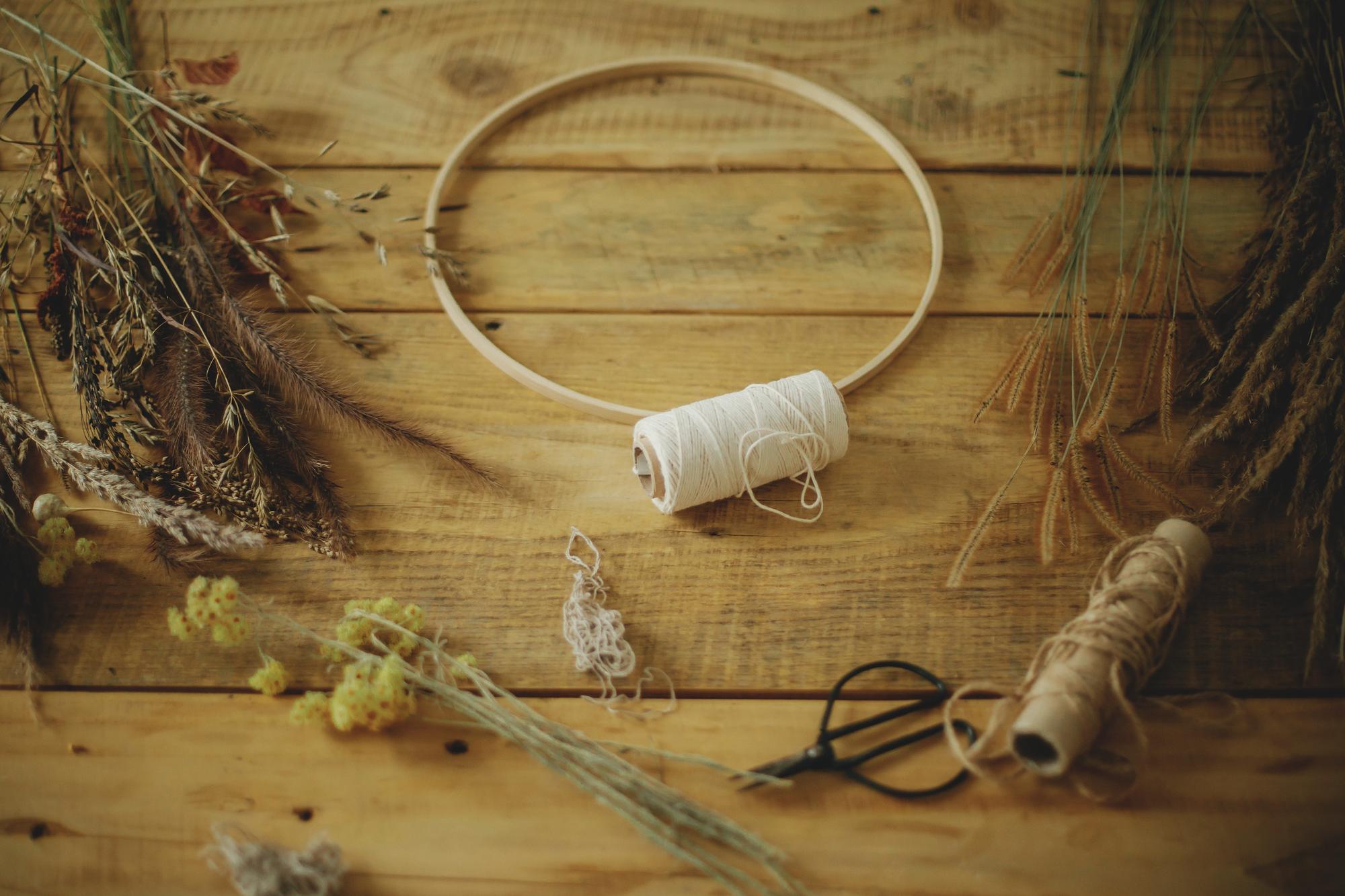 Workshop table with threads, needles and a wooden hoop
